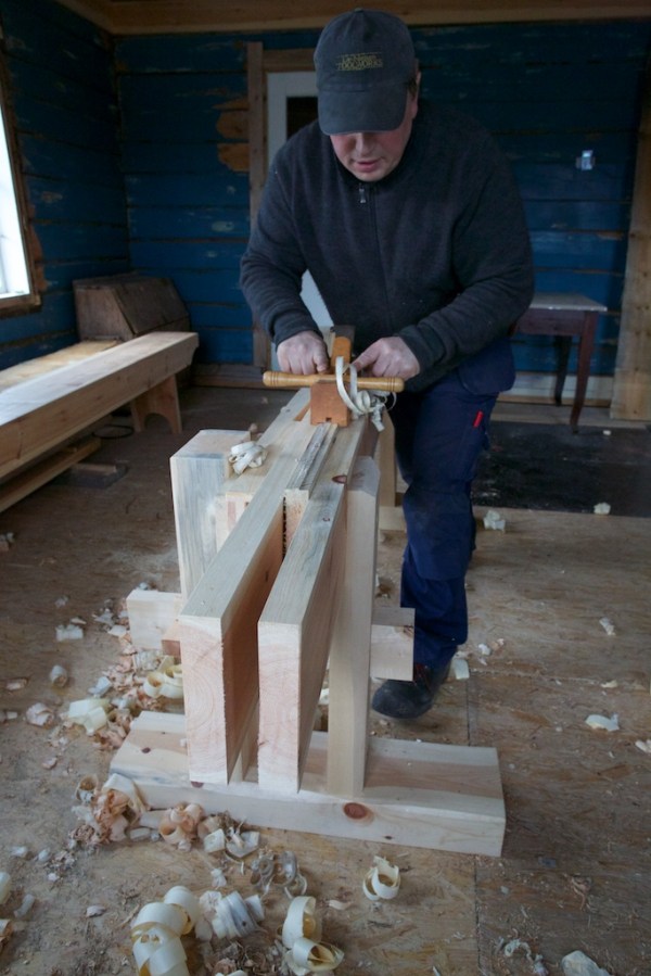 Roald Renmælmo høvlar fjør med ploghøvelen. På kvar side har plogen ein meie som gjer at høvestålet ikkje får ta meir når det når ned på overkant av langborda.