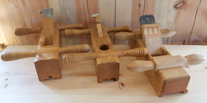 Høvlane på biletet er frå venstre, fjørhøvel og nothøvel (golvplogar) og skottokse. Golvplogane er kopiar av høvlane til Konrad Stenvold i Dividalen. Skottoksen er inspirert av ein skottokse frå garden Haugseth i Målselv. Bilete frå artikkelen "Handhøvling av golvbord - på jakt etter skottbenken". Foto: Roald Renmælmo