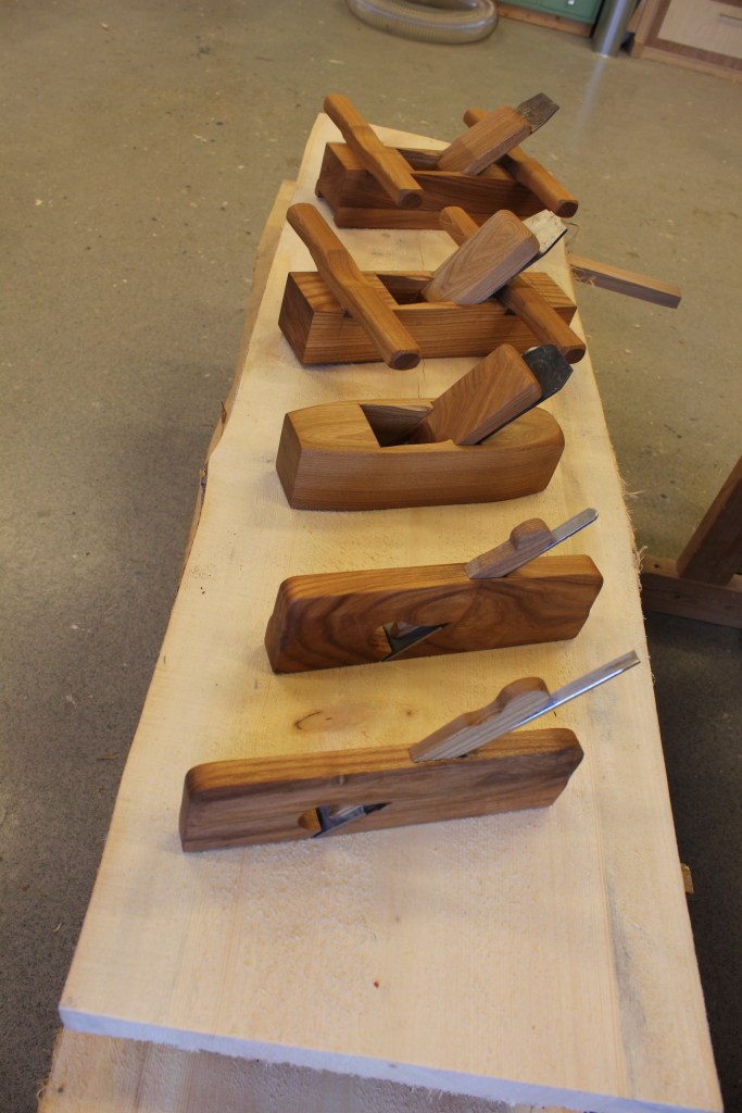 Fem høvler laget i serie. Skottokse, slettokse, pusshøvel, og to simshøvler.