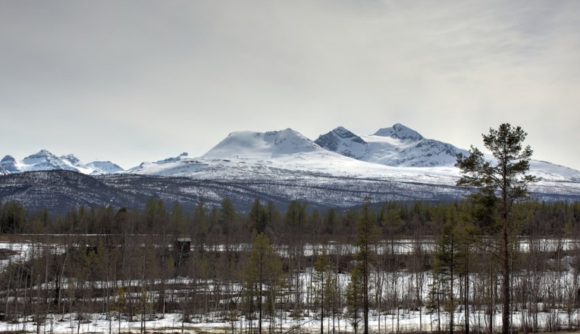 Etter kalenderen skulle det nærme seg vår på denne tida. Han har late vente på seg men i dag har han dukka opp med sol og temperatur på opp mot 20 grader. Det har gjort solid innhogg på snøen her i låglandet. Istindan, fjella på biletet er framleis heilt snødekte og snøen ligg langt ned i skogen. Dette er utsikta frå snikkarverkstaden min her på Lyngstad. Foto: Roald Renmælmo
