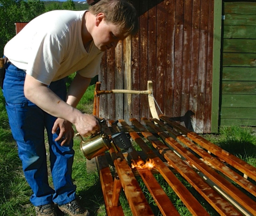 Eg brukar ei bensinfyrt blåselampe for å brenne tjæren inn i veden. På denne måten vert overflata snarare tørr og kleber mindre. Arbeidsmåten har eg lært av sledemakaren Johan Beddari. Foto: Siv Holmin