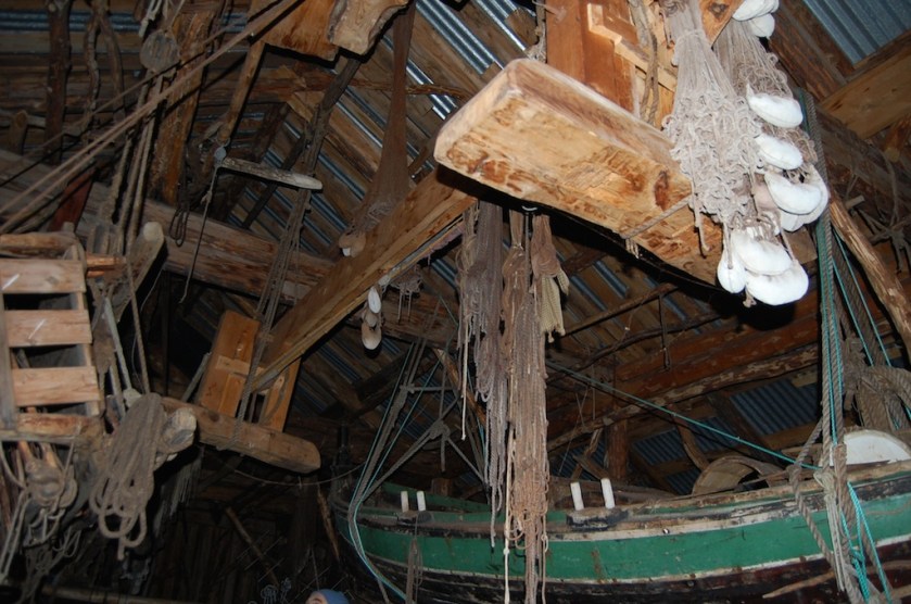 Skottbenken er heist opp og henger under samhaldarane i naustet. Foto: Oalv Austlid, Troms Fylkeskommune