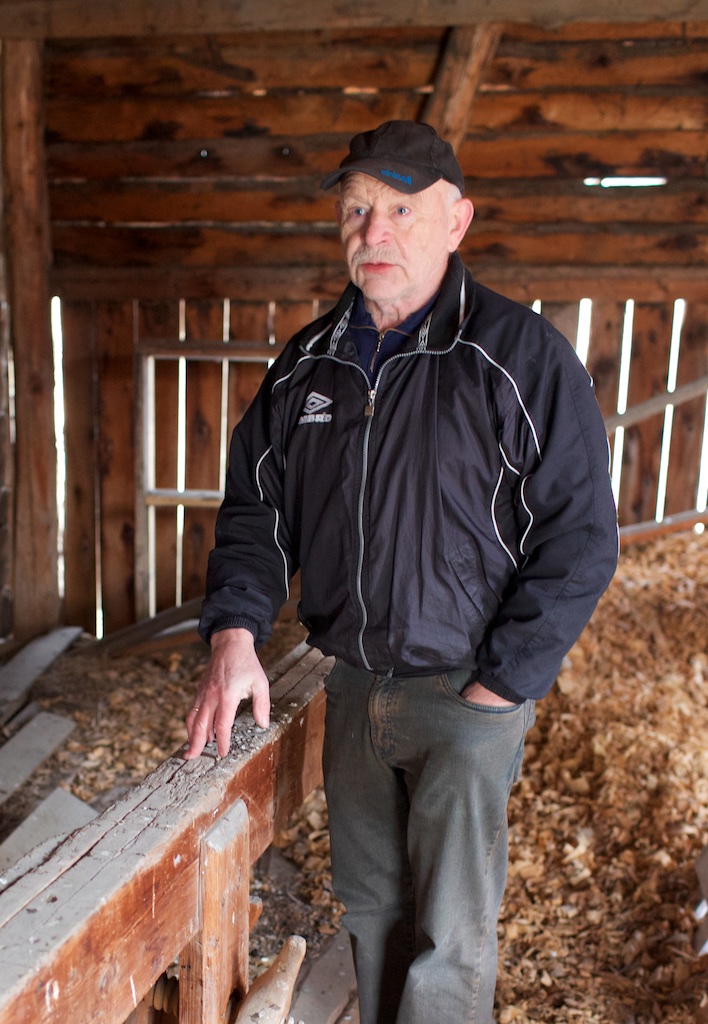 Peder Evjen ved sida av skottbenken og med høvelspona frå sist benken var i bruk. Foto: Roald Renmælmo