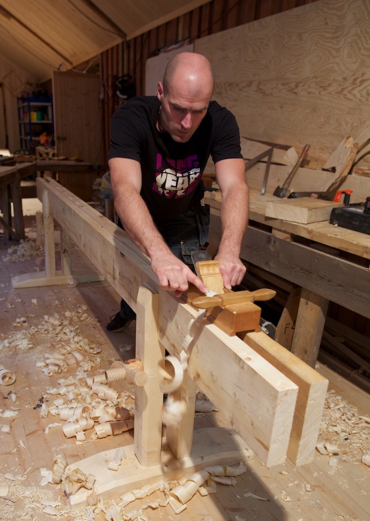 Robert Nilsen var den fyrste til å få ferdig skottbenk på kurset. Her er han i gang med prøvehøvling med lånt skottokse. Foto: Roald Renmæmo