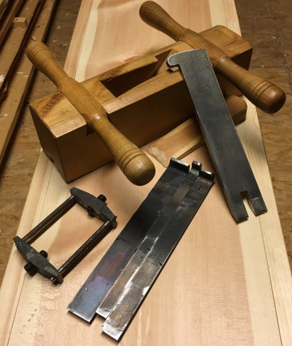 I bakgrunnen er min fyrste golvplog med stål frå Jon Dahlmo. Denne er kring 14 år gamal og har vore mykje brukt. I framkant ligg det nye stålet som Jon har smidd i haust. Det består av tre smale stål som vert lagt saman og klemt fast med settskruvar på sida av høvelstokken. Foto: Roald Renmælmo